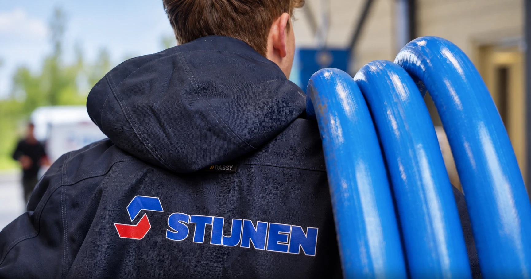 Stijnen-medewerker met blauwe leidingen over zijn schouder